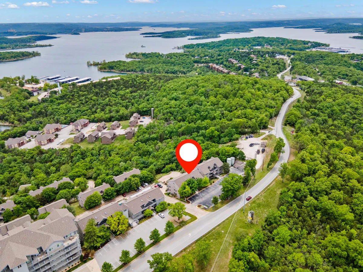 This image features a panoramic view of lush greenery, a calm waterfront, residential buildings, and a winding roadway. The tranquil setting is ideal for lakeside strolls, boating, and connecting with nature—perfect for couples looking to explore and make memories together.